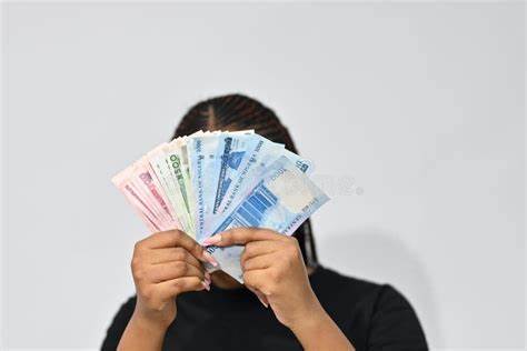 invest - a lady holding naira notes in front of her face